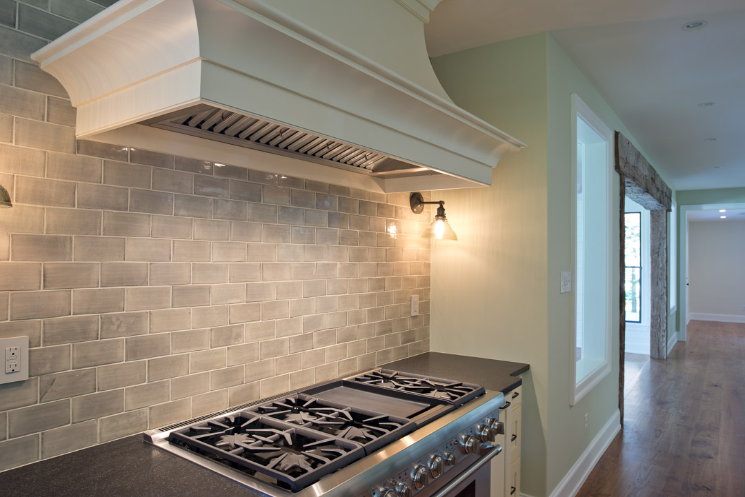 Winslow Interiors - built-in range with hood and subway tile